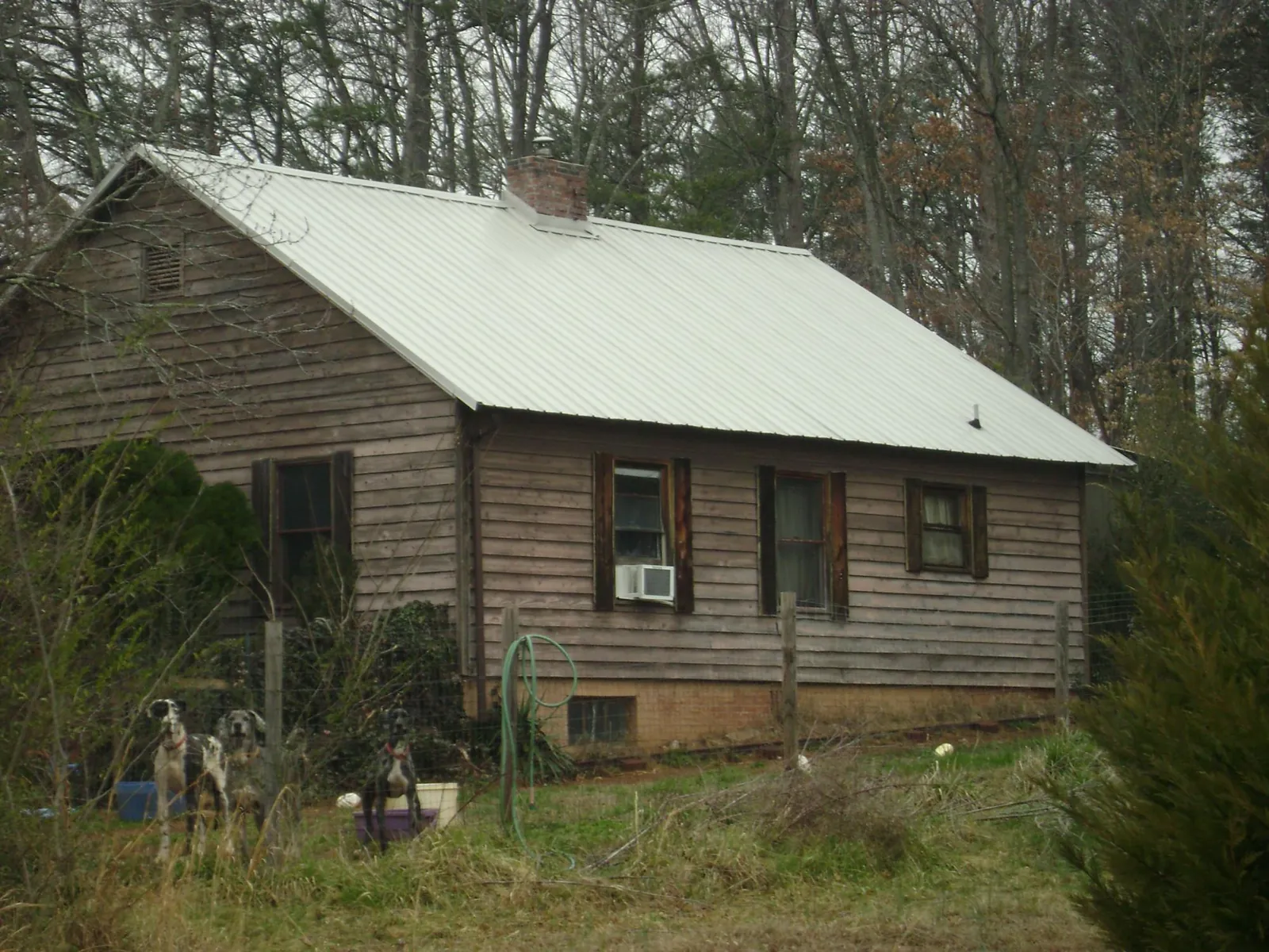 White metal roof on an old wood sided farmhouse, from a Metal Roof Installation job in Winnett